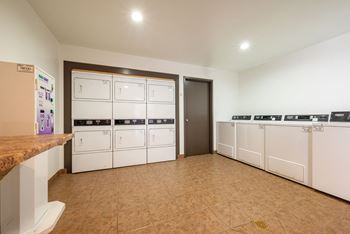 a laundry room with white washers and dryers